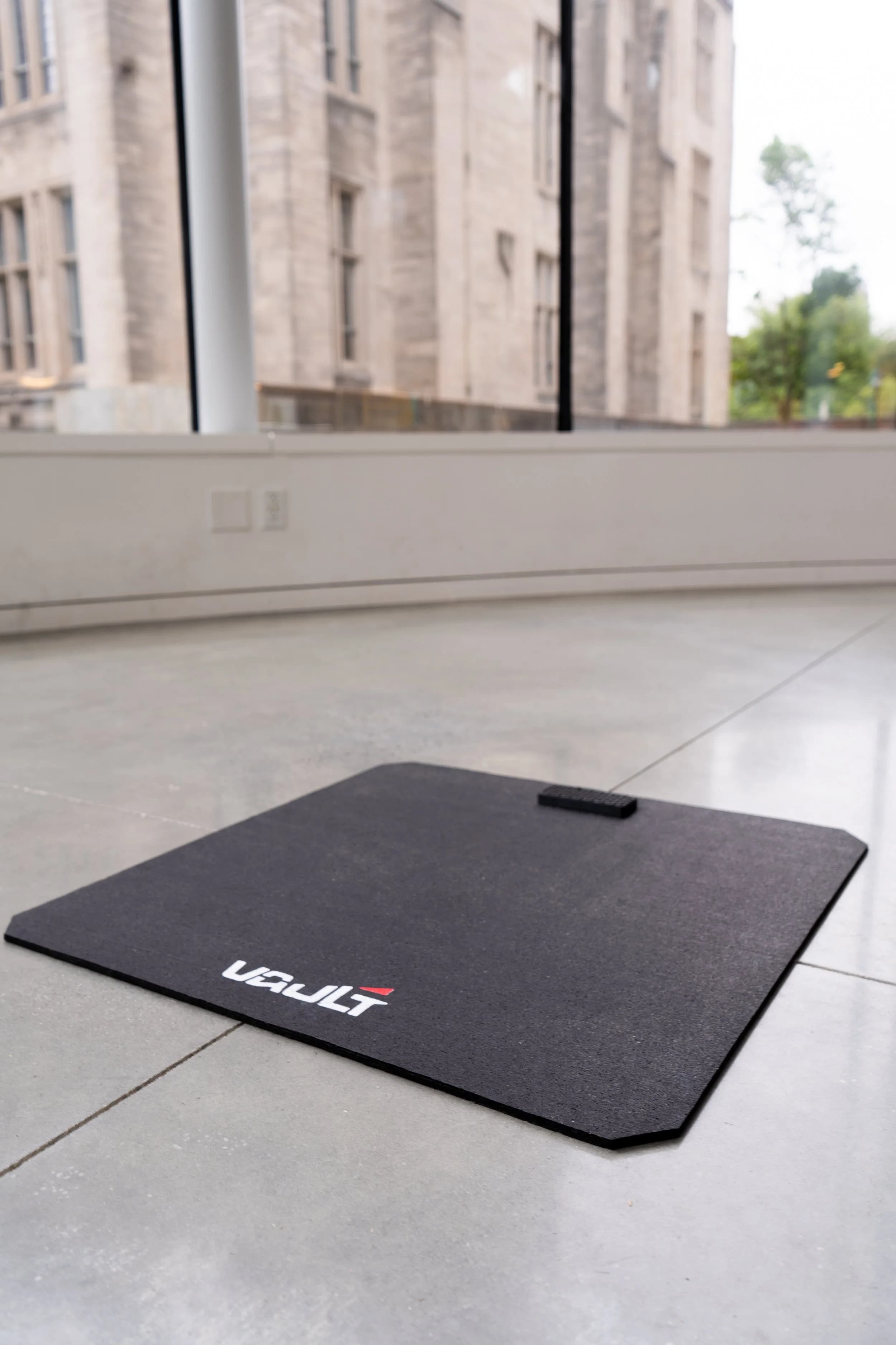 The Vault force platform resting on a polished studio floor in daylight.